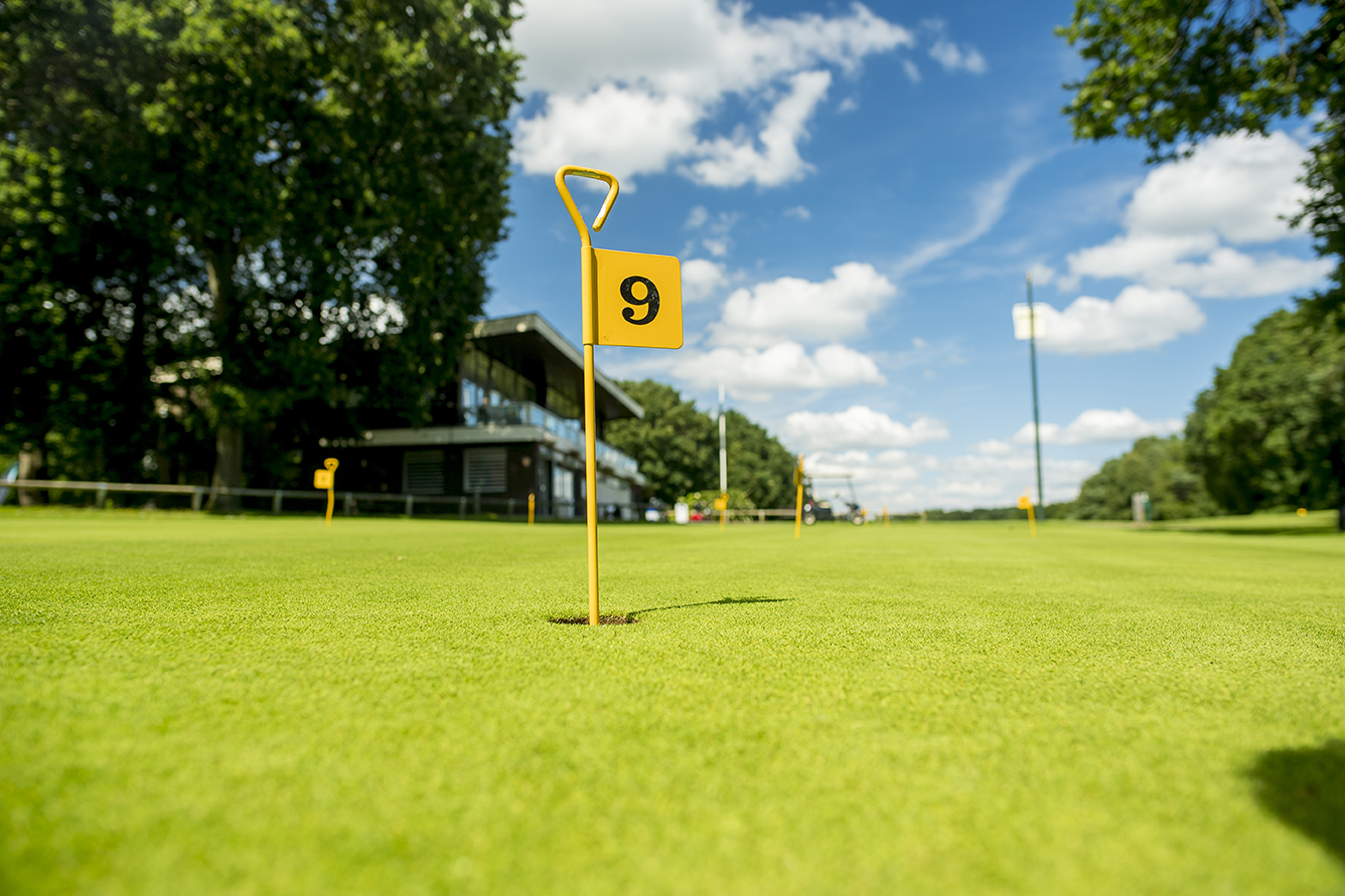 View of hole 9 on the golf course with a yellow marker flag in the hole