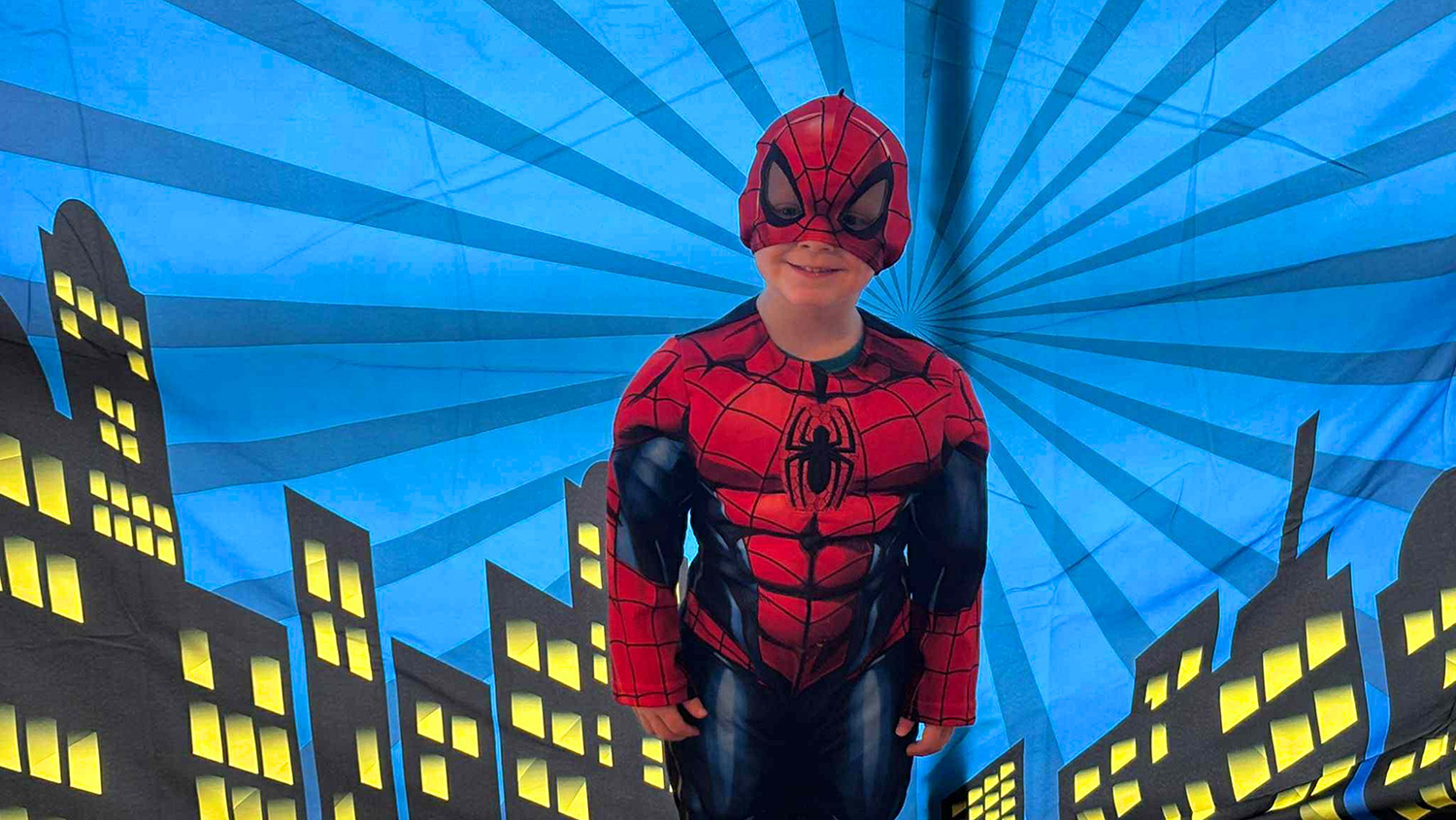 Boy dressed in spiderman costume.