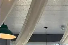 Function room dressed for wedding reception with arch of flowers.